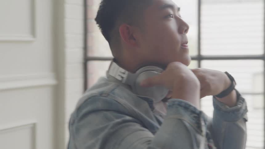 A male is resting and puts headphones on his ears