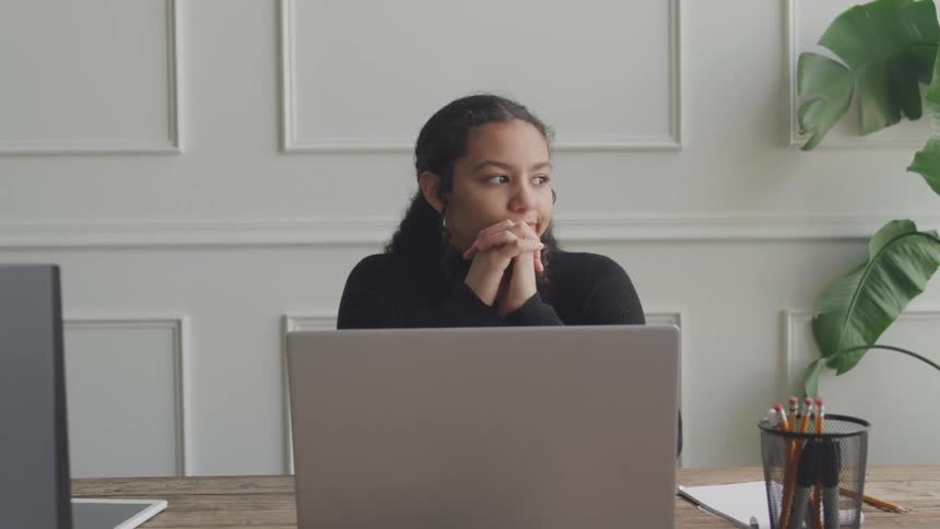 A woman is thinking at her desk