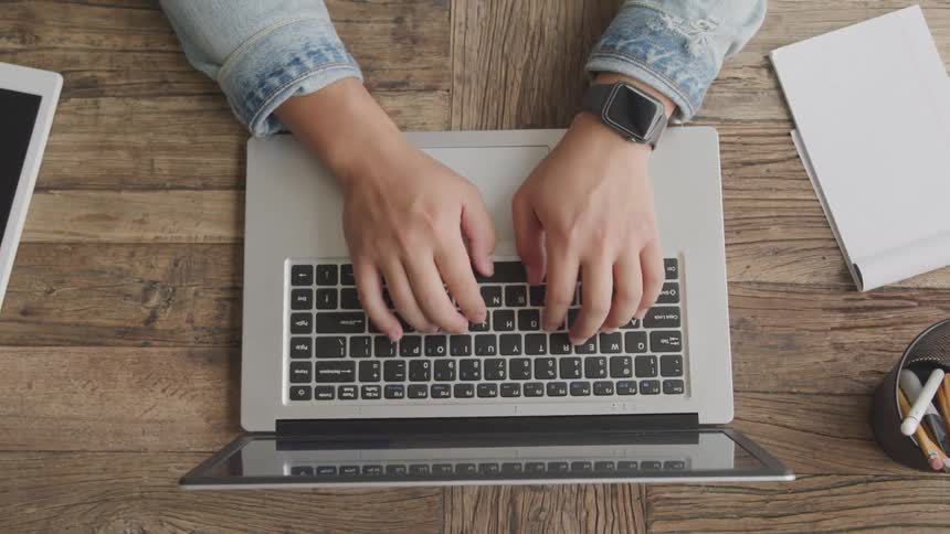 A person is typing on his laptop