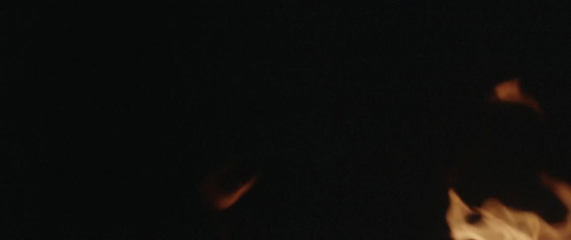 A fire blazes in a dark area