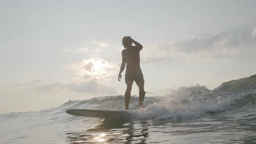 A group of people are surfing on large waves in the ocean