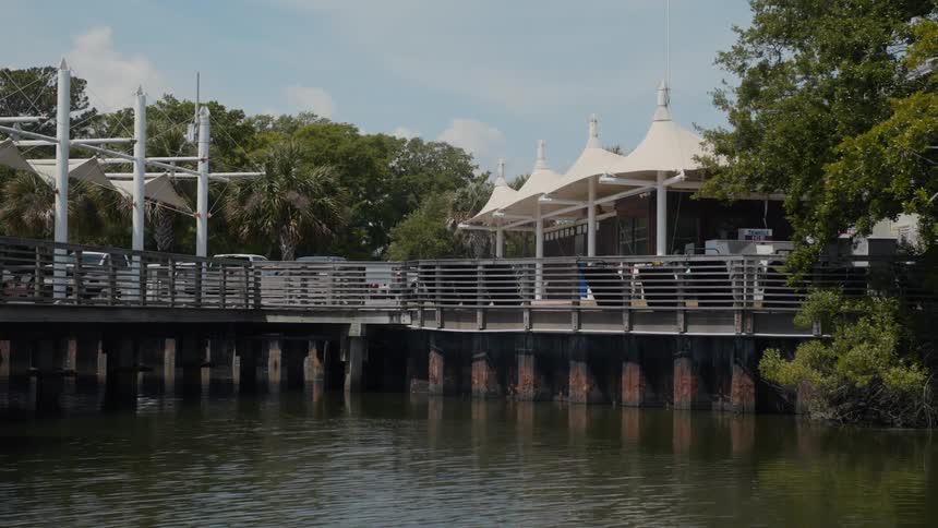 Canvas forms covered areas near a building and its parking lot on the water on a cloudy day