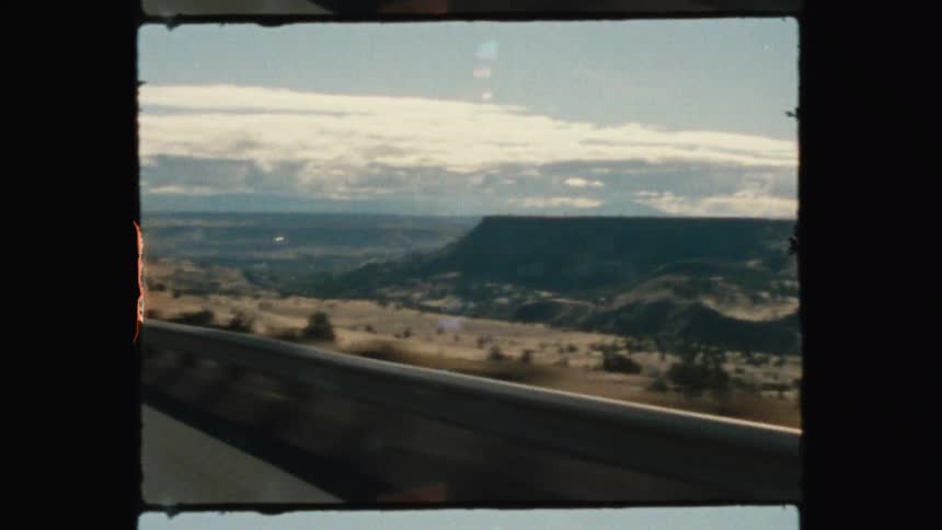 Rural highway overlooks the fields and valleys near plateaus on a cloudy day