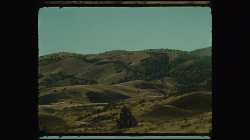 The camera pans across a mountainous landscape