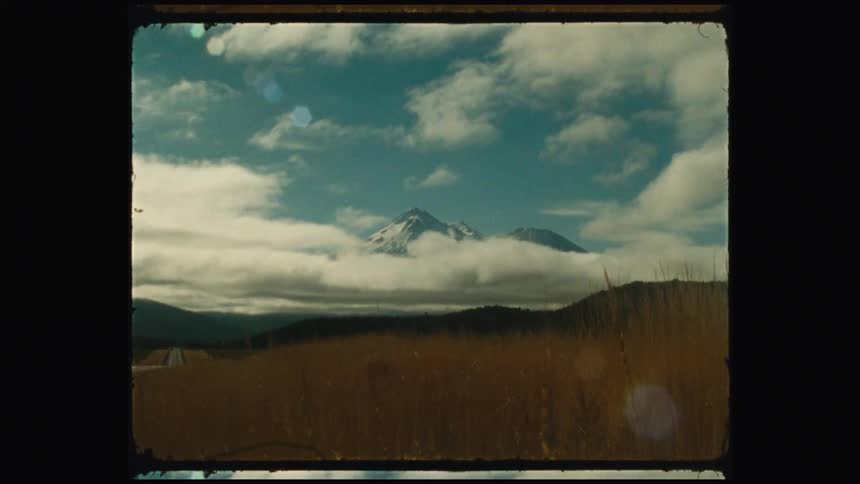 A view of a mountain in the distance with clouds around the base