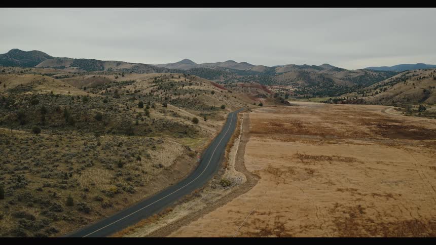Aerial view of a highway along the mountains through the desert