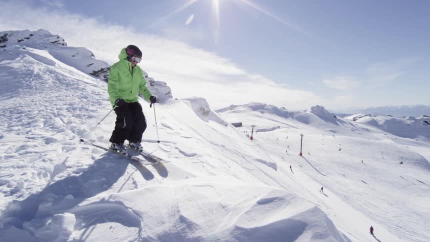 Skier skiing down a large hill going over a jump