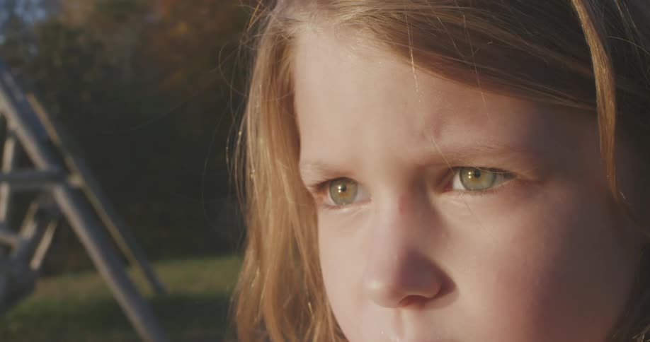Young red-haired girl staring intensely at something in front of her