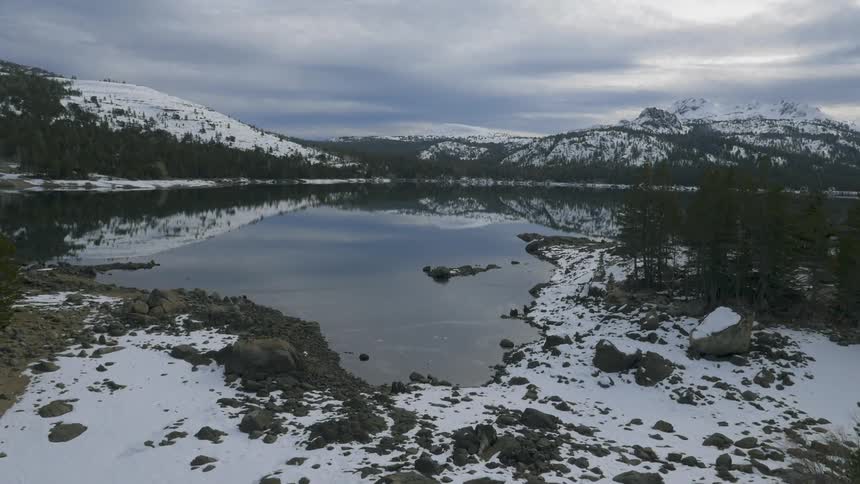 A mountain lake is shown in the winter