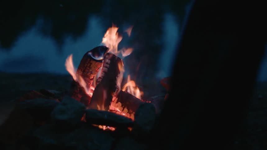 Flames burning on a pile of wood at night
