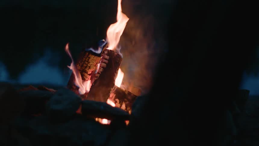 Bonfire lit in a dark outdoor location