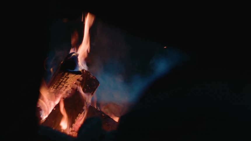 Flames burning a pile of wood at night