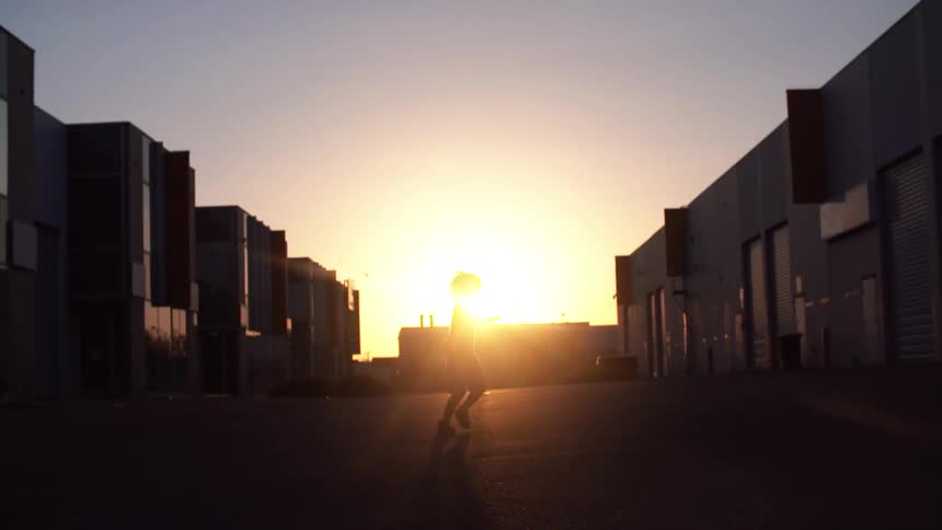 Child spins with sun setting in the background
