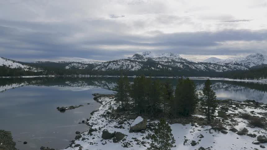A mountain lake is shown in the winter