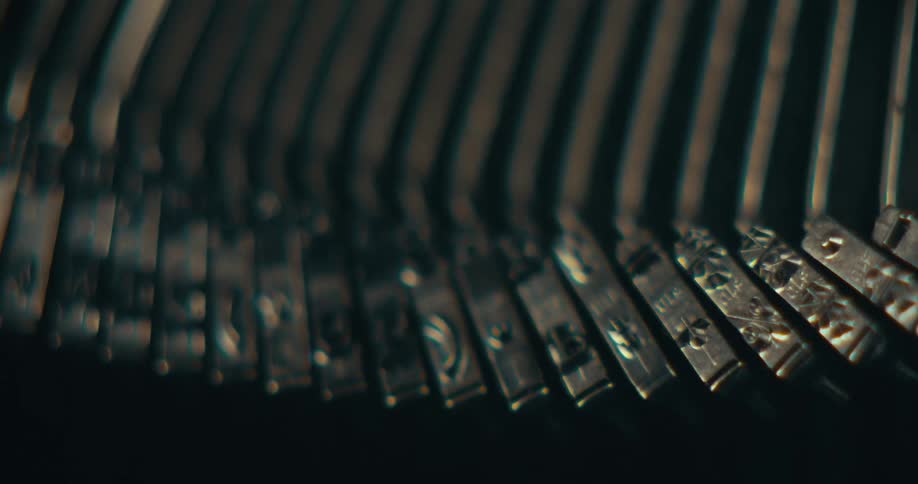 The inside of an antique typewriter is shown with the metal key sticks going up and down as if typing