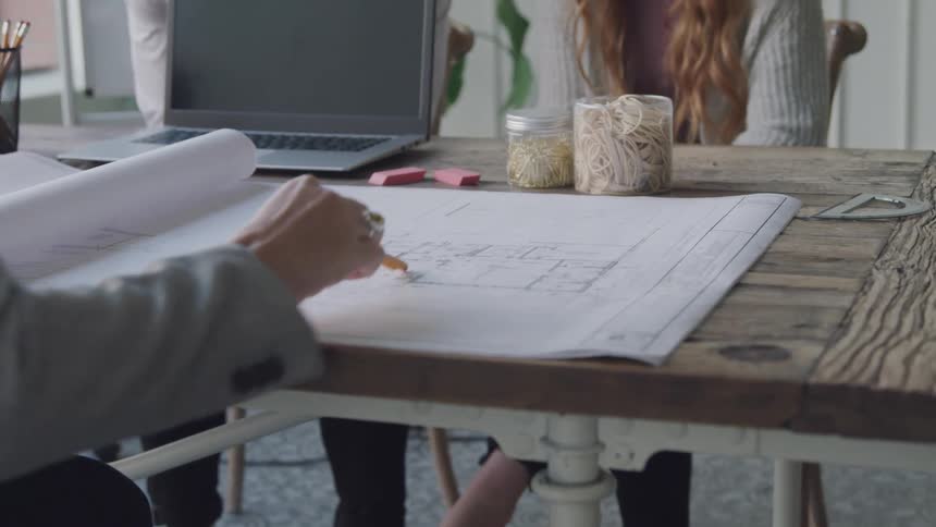Architect going over blueprints with her clients in her office