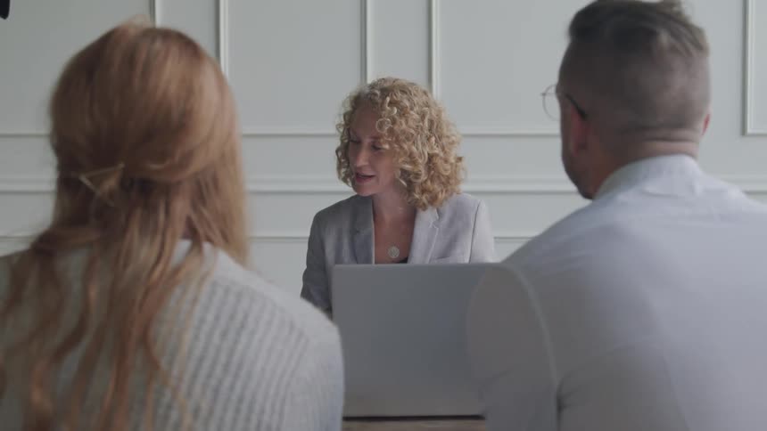 A woman looks at papers and talks with coworkers