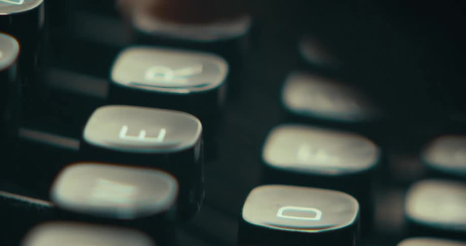 Extreme close up of person typing on keys on an old school typewriter