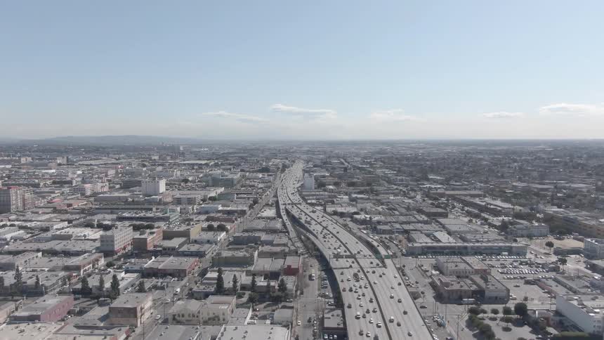An aerial view of a bustling city with heavy traffic on a major highway running through it