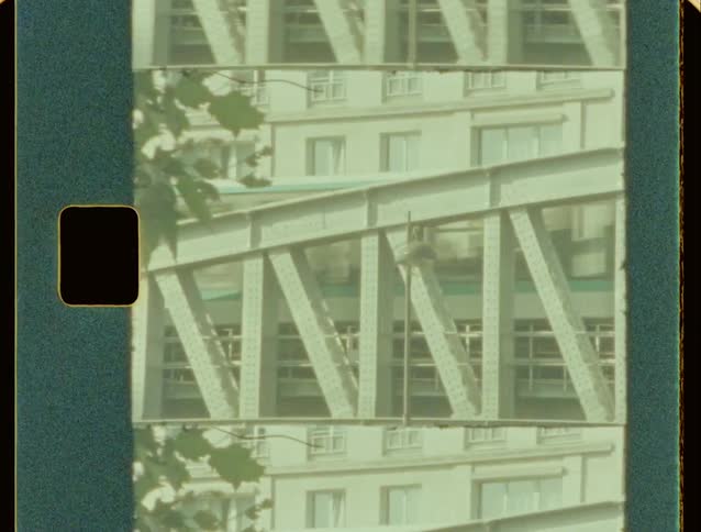 Elevated trains cross over an urban street near an intersection on a summer day
