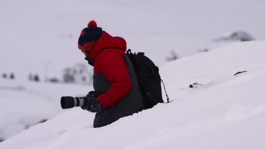 A footage of a person holding a camera in the snow