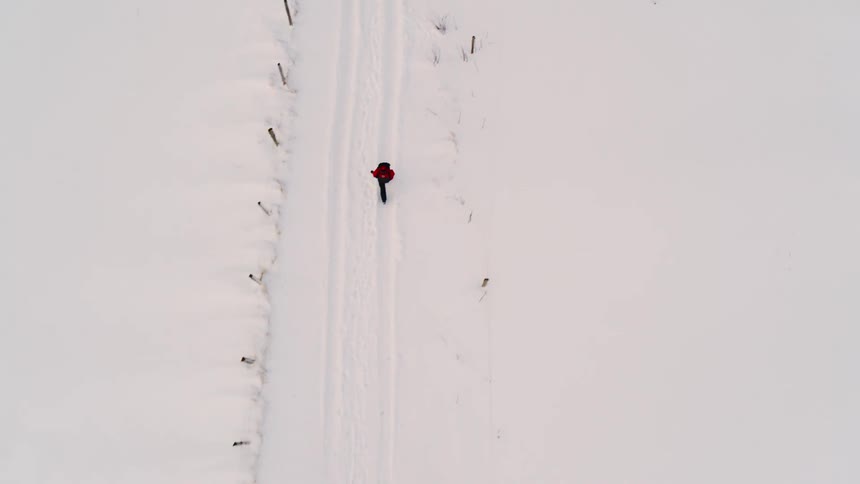 Top view of a man walking on snow