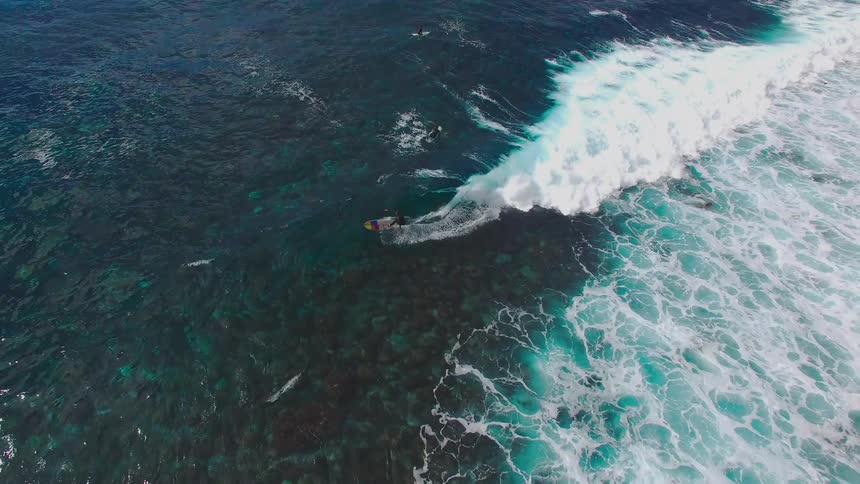 An aerial footage of a person surfing the sea waves