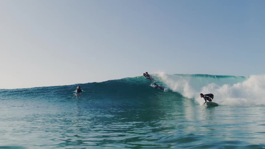 A footage of surfers in surfing the sea wave