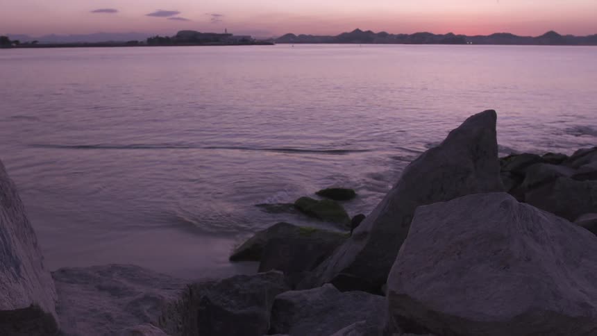 The sun is rising on the shore