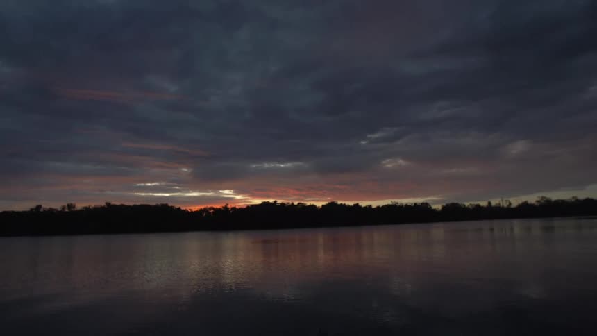 The sun is setting on the lake