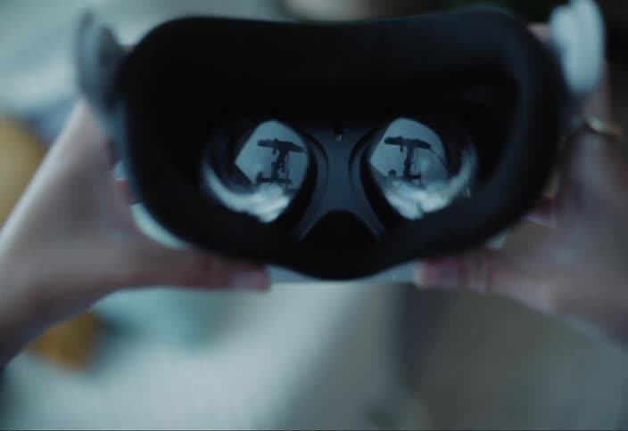 A person is placing a vr headset over their eyes preparing to enter a virtual reality environment