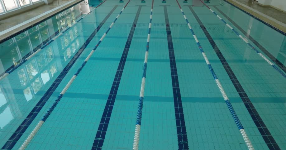 A large indoor pool is shown with ropes extending from top to bottom creating six rows