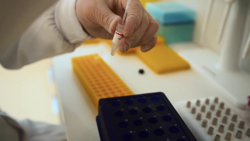 A scientist is injecting into a vial