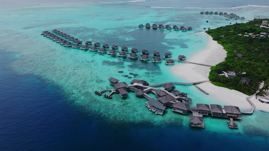 Travel resort island destination aerial with over the water bungalows and a white sandy beach