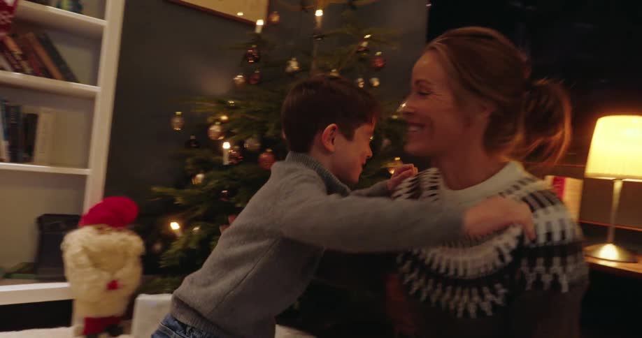 A mother gives her son a christmas present