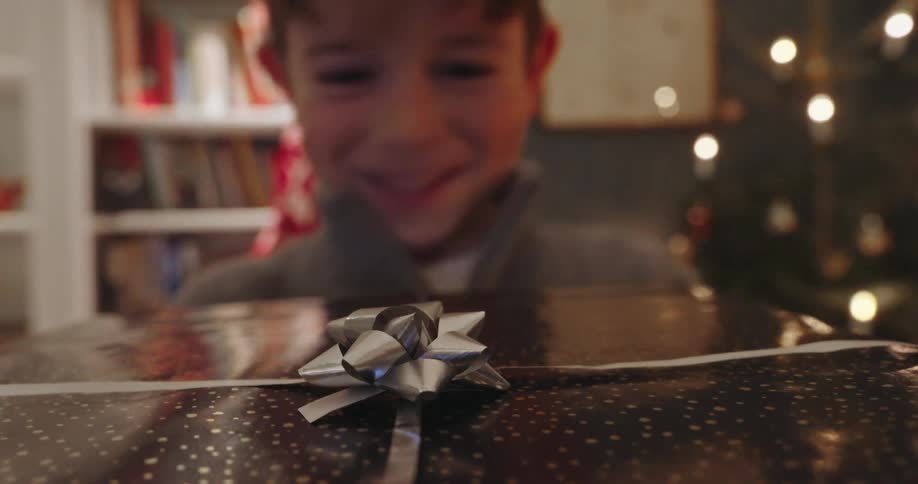 Point of view handing a gift wrapped box to a happy child