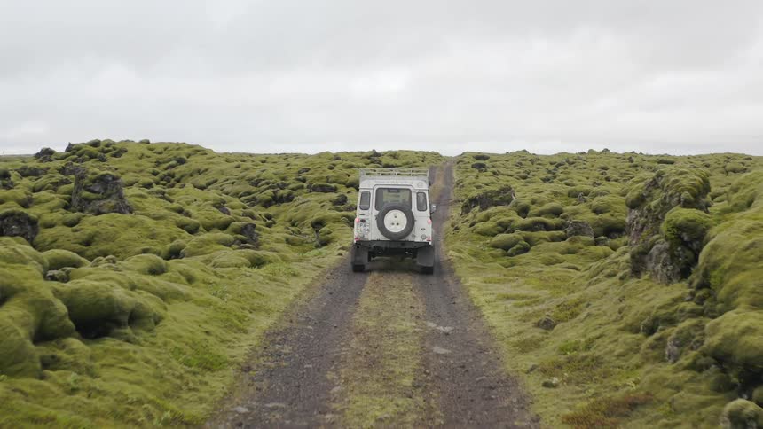 The off road vehicle drives on the trial past the rocks
