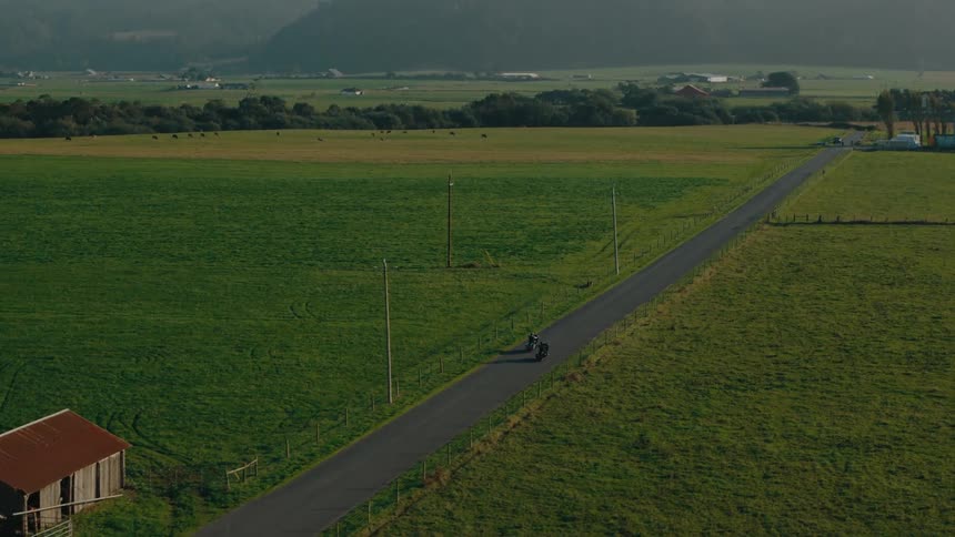 Motorcycles riding along a road in the middle of the countryside