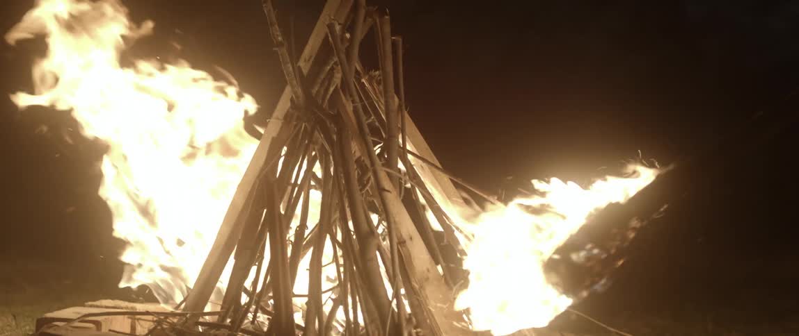 A person lights a fire in the dark