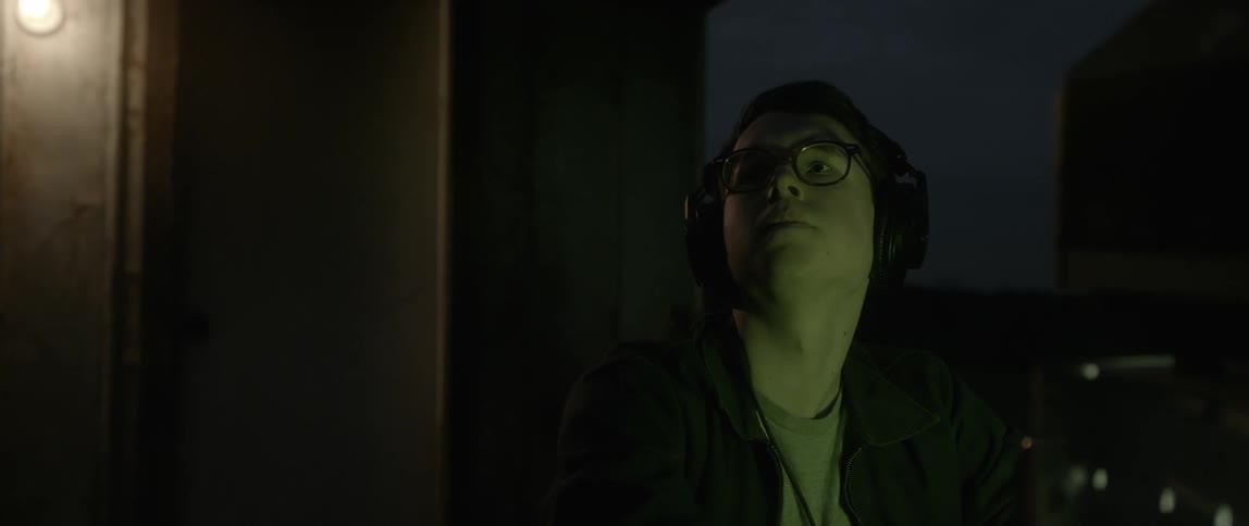 A man wearing headphones in a dark room