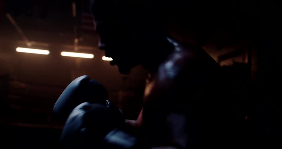 A boxer moves around and punches the heavy bag