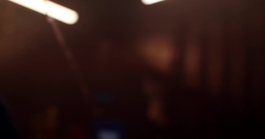 A man is boxing in a dark lit room and wearing gloves