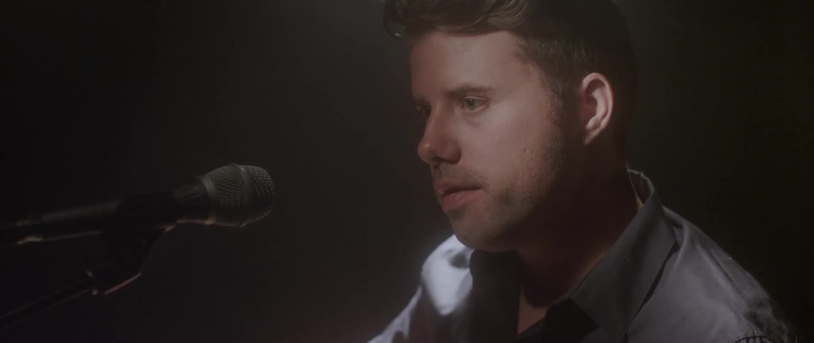 A man is beginning to perform in front of a microphone