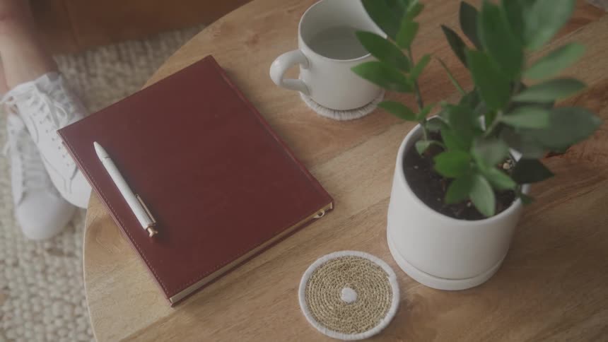 A person sits by a notebook and pen