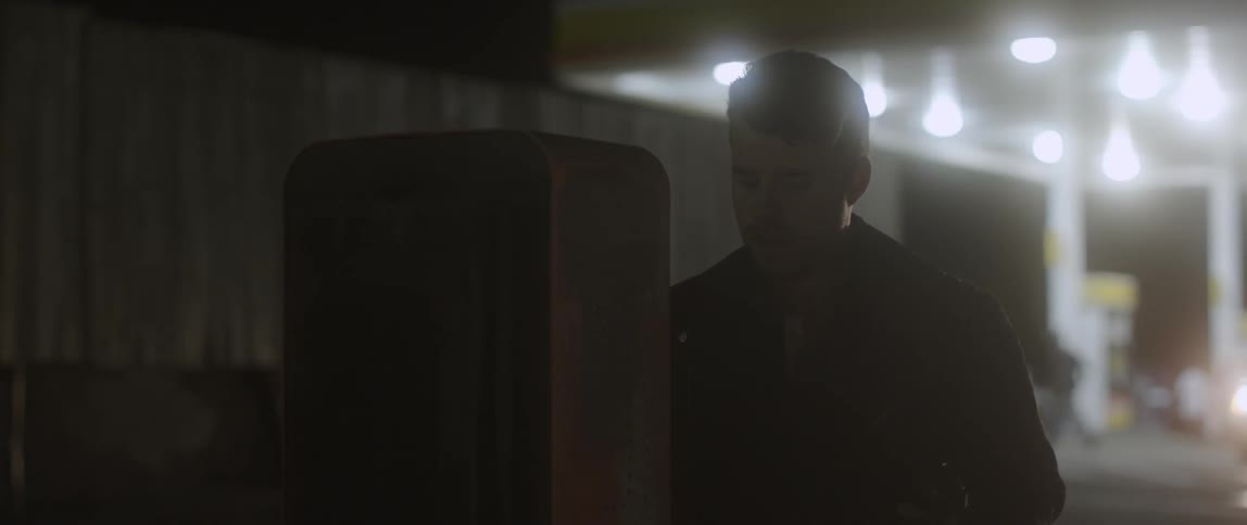 A man picks up a payphone changes his mind and walks away