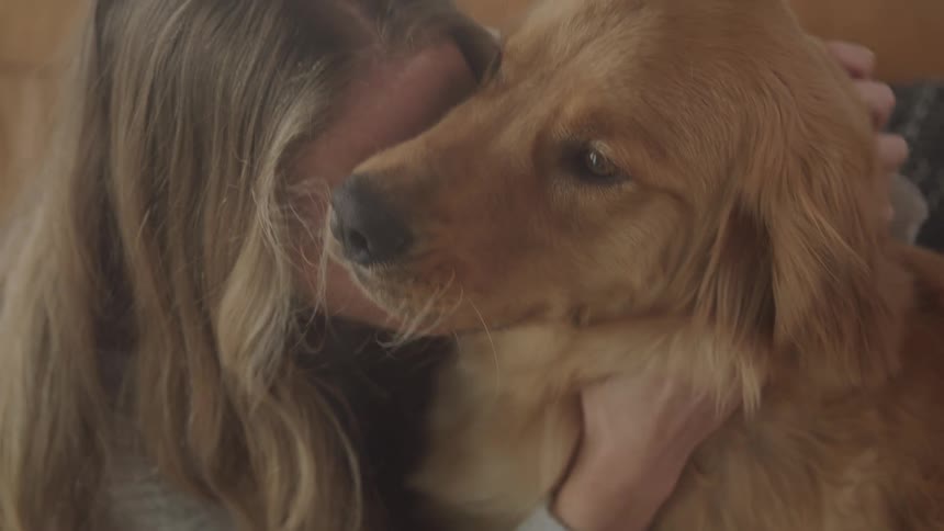 A woman is hugging her dog
