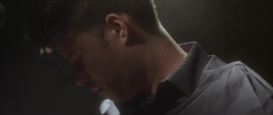 A man turns his head to look up and then back down