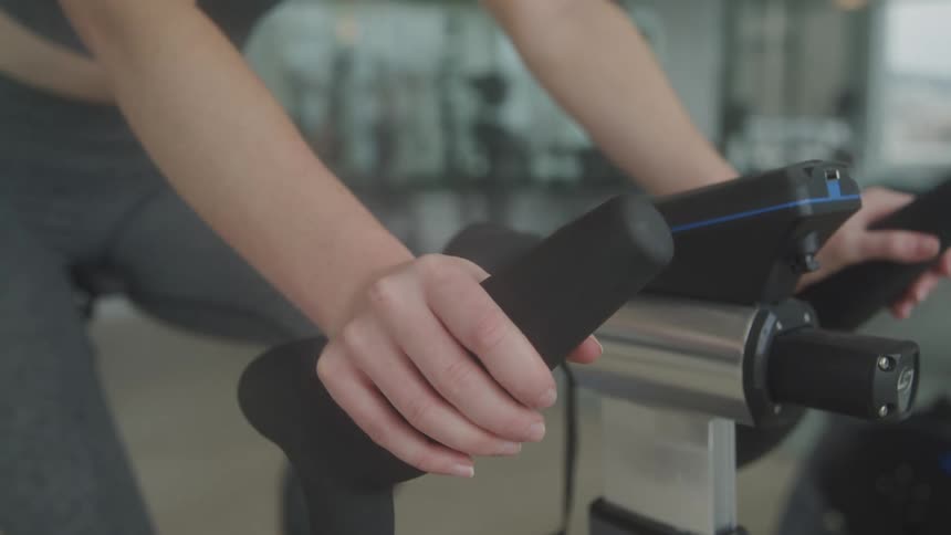 A woman is working out on an exercise bike in the gym