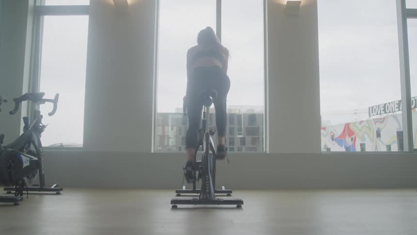 Girl in the gym doing exercise bike