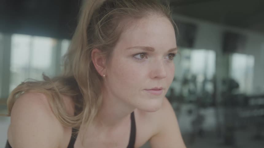 A woman is riding an exercise bike